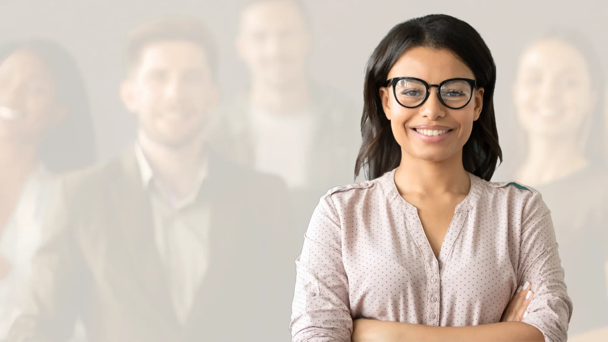 Smiling woman in a professional setting with colleagues.
