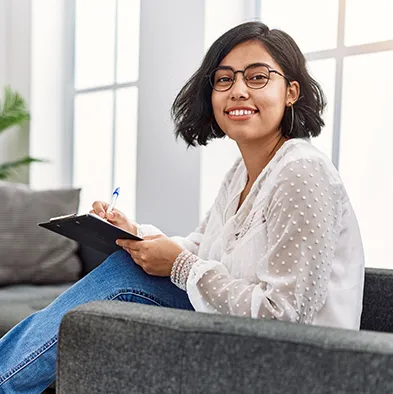 Young Hispanic female therapist smiling confidently in a consultation office.